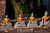 Ayutthaya, Thailand. Wat Yai Chai Mongkhon, saffron-draped Buddha statues inside the temple compound.